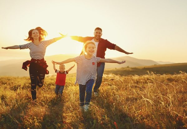 Happy family: mother, father, children son and  daughter on nature  on sunset